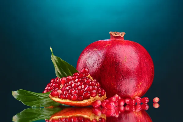 Mogen granatäpple frukt med lämnar på blå bakgrund — Stockfoto