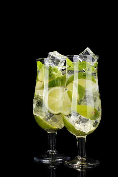 stock image Glasses of cocktails with lime and mint on black background