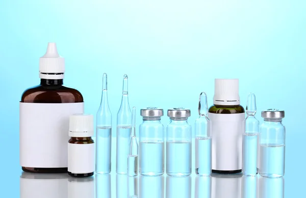 Medicinsk flaskor och ampuller på blå bakgrund — Stockfoto