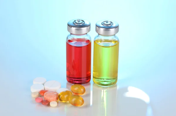 Tabletter och ampuller på blå bakgrund — Stockfoto