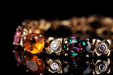 Beautiful bracelet with precious stones on black background clipart