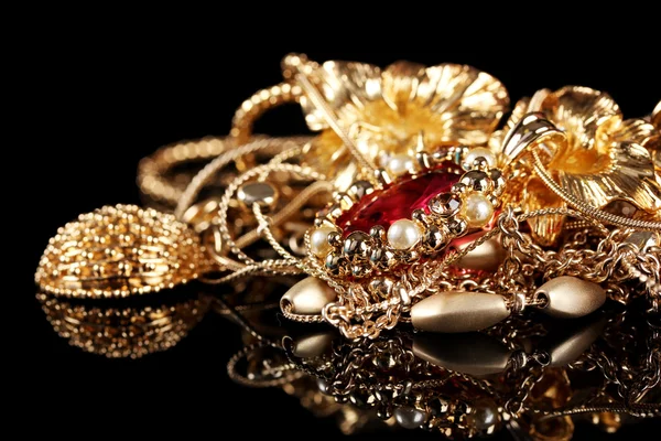Various gold jewellery on black background — Stock Photo, Image