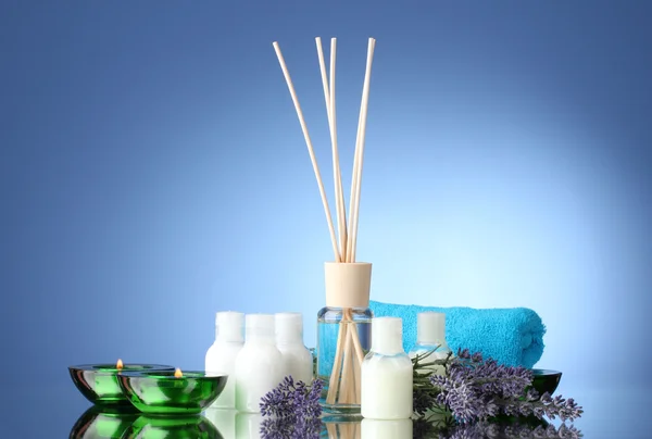 Flasche Lufterfrischer, Lavendel, Handtuch und Kerzen auf blauem Hintergrund — Stockfoto