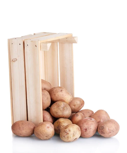 Patatas crudas en una caja de madera aislada en blanco — Foto de Stock