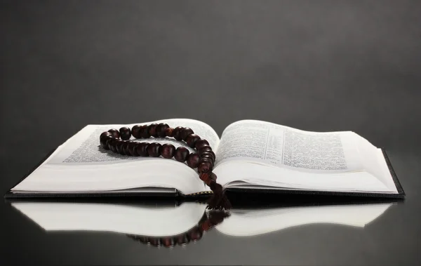 Bible russe et chapelet en bois sur fond noir — Photo