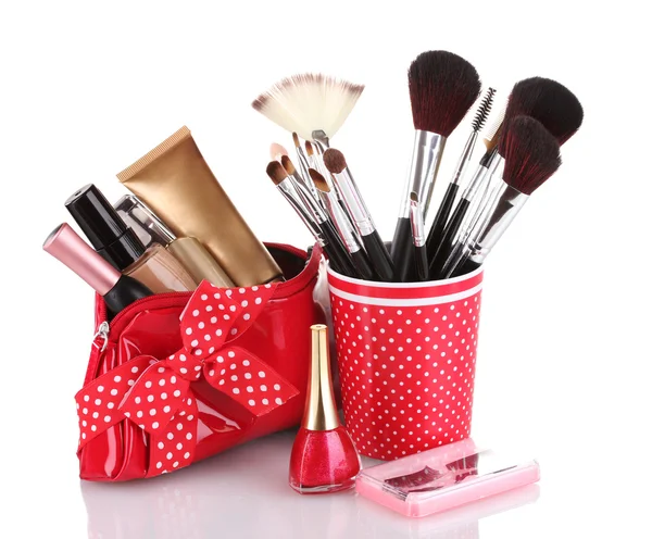 Vetro rosso con pennelli e borsa per il trucco con cosmetici isolati su bianco — Foto Stock