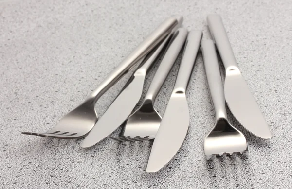 Vidličky a nože na mramorový stůl — Stock fotografie
