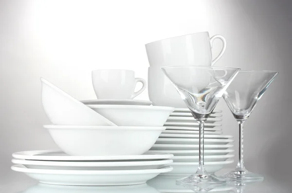 Empty bowls, plates, cups and glasses on grey background — Stock Photo, Image