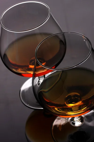 Two glasses of cognac on grey background closeup — Stock Photo, Image