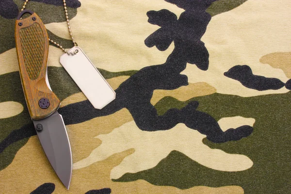 Insignes de l'armée et couteau sur fond de camouflage — Photo