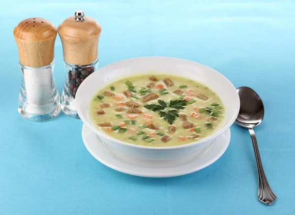 Üzerinde mavi masa örtüsü üzerinde beyaz izole lezzetli çorba — Stok fotoğraf