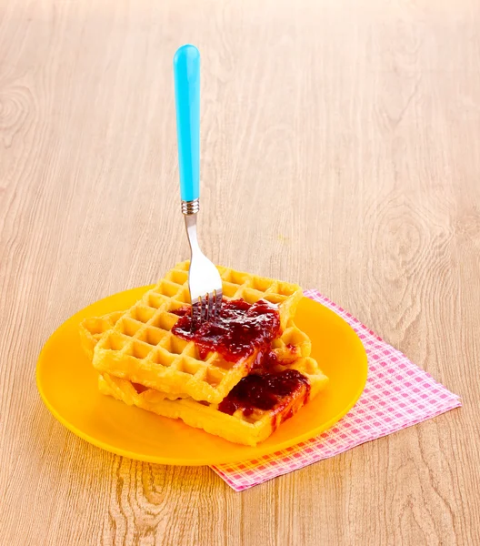 Waffles saborosos com geléia na placa no fundo de madeira — Fotografia de Stock