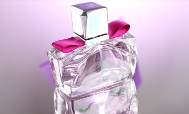 Women's perfume in beautiful bottle on pink background clipart