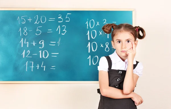 Beautiful little girl standing near blackboard in the classroom — Stock Photo, Image