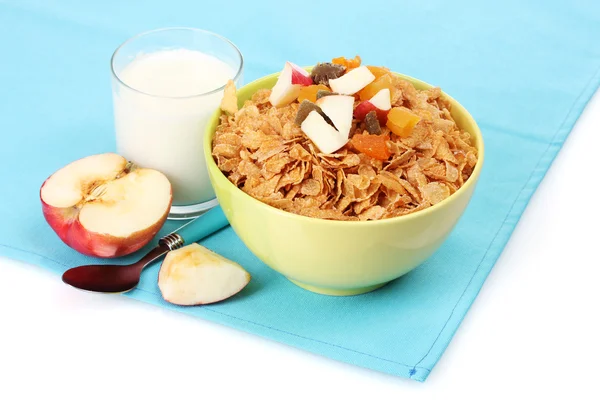 Välsmakande cornflakes i skål med torkade frukter, glas mjölk och apple på blå — Stockfoto