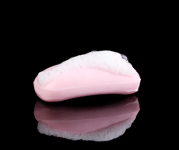 Sabão rosa com espuma isolada em preto — Fotografia de Stock