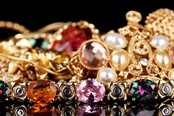 Várias jóias de ouro sobre fundo preto — Fotografia de Stock