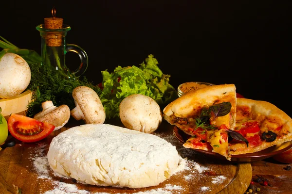 Вкусное тесто для пиццы, специи и овощи на деревянном столе на коричневом бэкге — стоковое фото