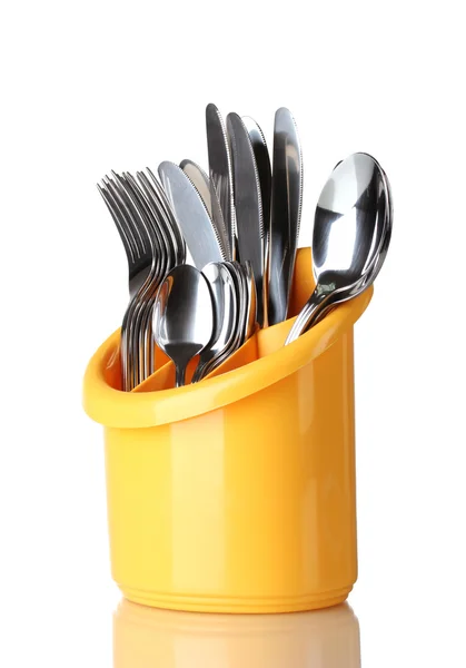 Кухонные столовые приборы, ножи, вилки и ложки в желтой стойке изолированы на белом — стоковое фото