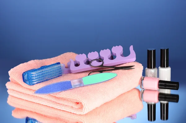 Pedicure ingesteld op roze handdoek op blauwe achtergrond — Stockfoto