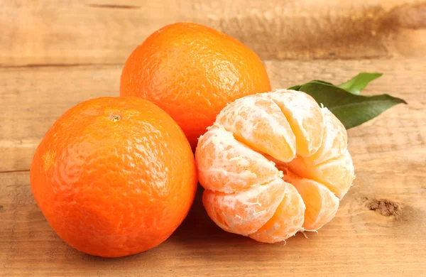 Tangerines with leaf on wooden table — Stock Photo, Image