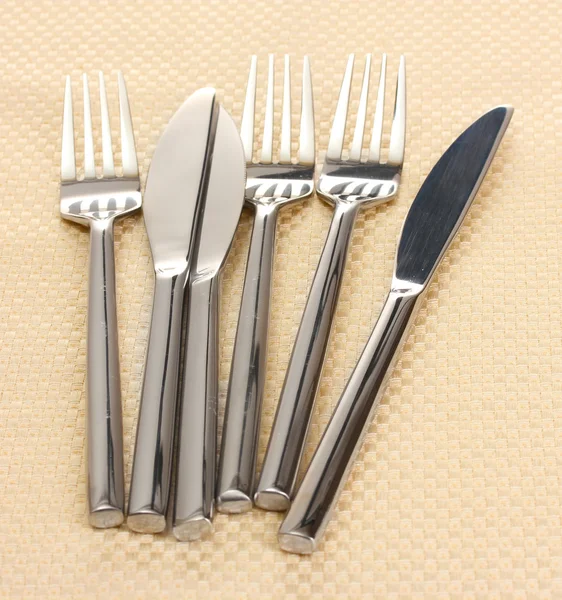 Vidličky a nože na béžový ubrus — Stock fotografie