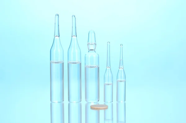 Medical ampoules on blue background — Stock Photo, Image