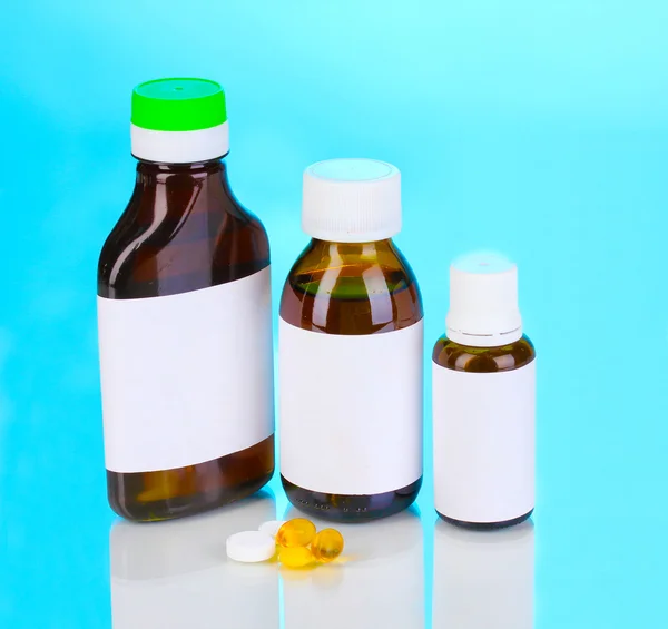 Lékařskou lahví a tablety na modrém pozadí — Stock fotografie
