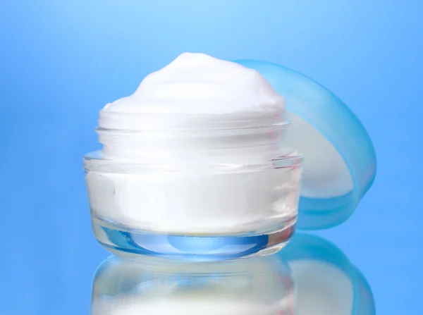 Cosmetic cream on blue background — Stock Photo, Image