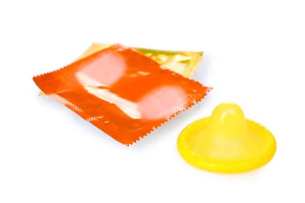 Preservativo amarelo com embalagens isoladas em branco — Fotografia de Stock