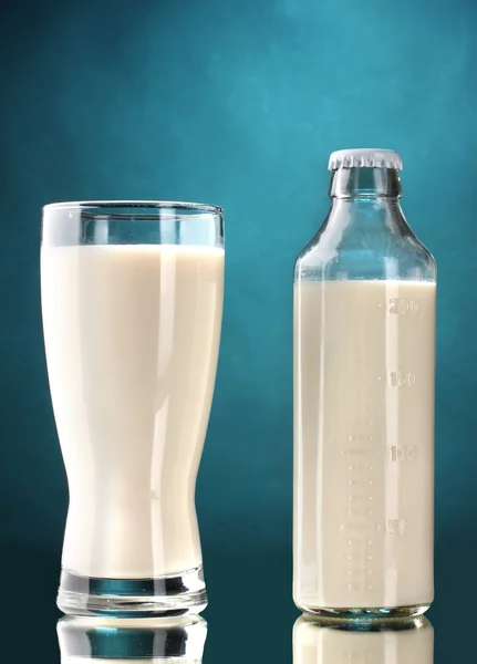 Μπουκάλι και ποτήρι γάλα σε μπλε φόντο — Φωτογραφία Αρχείου