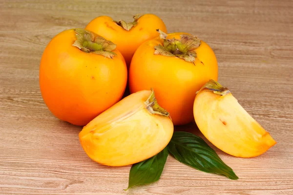 Appetizing persimmons on wooden background — Stock Photo, Image
