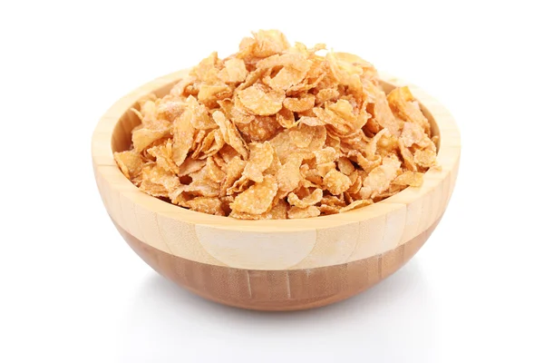 Tasty cornflakes in wooden bowl isolated on white — Stock Photo, Image