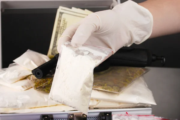 Cocaïne et marijuana avec arme dans une valise avec la main tenant un paquet de — Photo