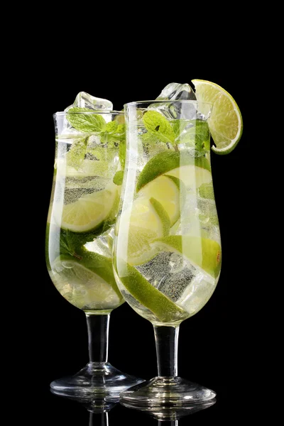 Glasses of cocktails with lime and mint on black background — Stock Photo, Image