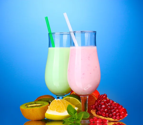 Milk shakes with fruits on blue background — Stock Photo, Image
