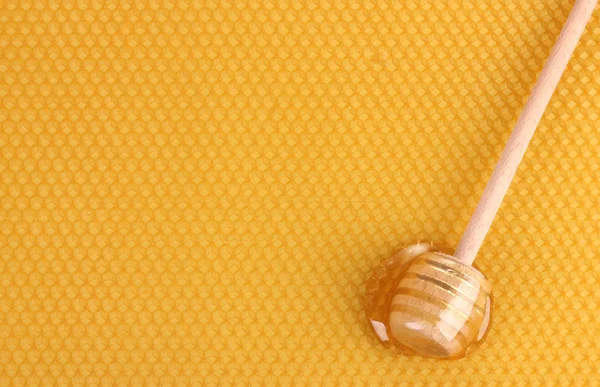 Gelbe schöne Wabe und hölzerner Honigtropfen mit Honig — Stockfoto