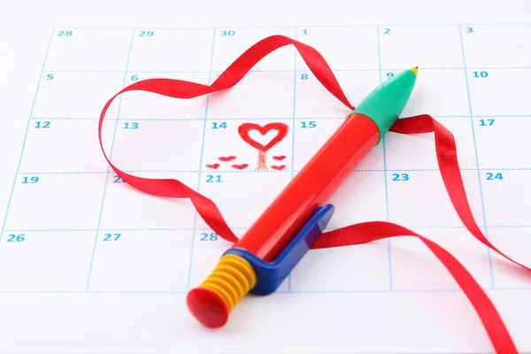 Календарь с сердцами, ручкой и лентой на День Святого Валентина — стоковое фото