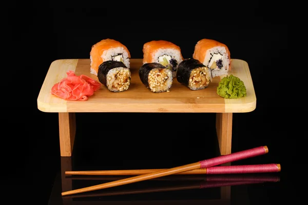 Tasty rolls served on wooden plate isolated on black — Stock Photo, Image