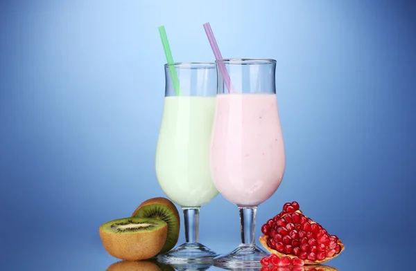 Milk shakes with fruits on blue background — Stock Photo, Image