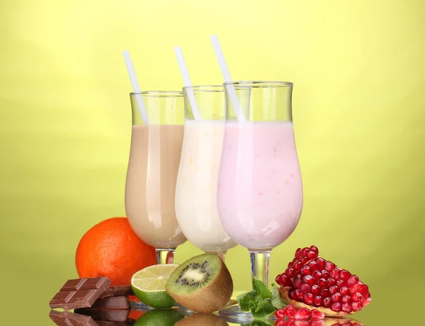 Frullati di latte con frutta e cioccolato su sfondo verde — Foto Stock
