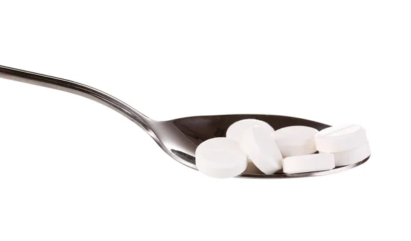 Spoon with pills isolated on white — Stock Photo, Image