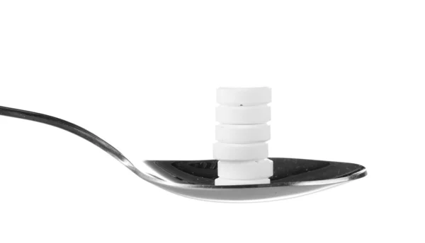 Löffel mit Tabletten isoliert auf weiß — Stockfoto
