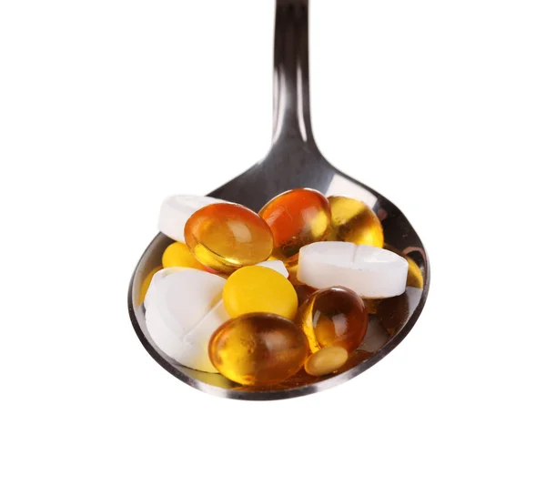 Cucchiaio con pillole isolate su bianco — Foto Stock
