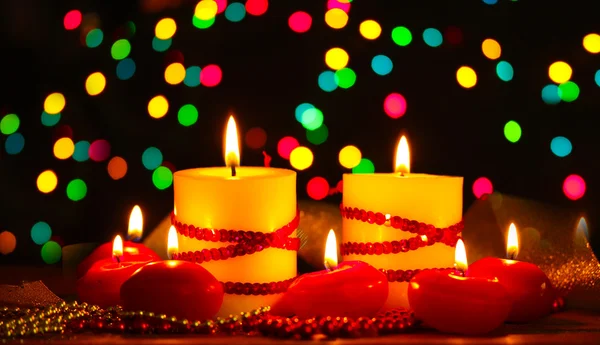 Belas velas e decoração na mesa de madeira no fundo brilhante — Fotografia de Stock