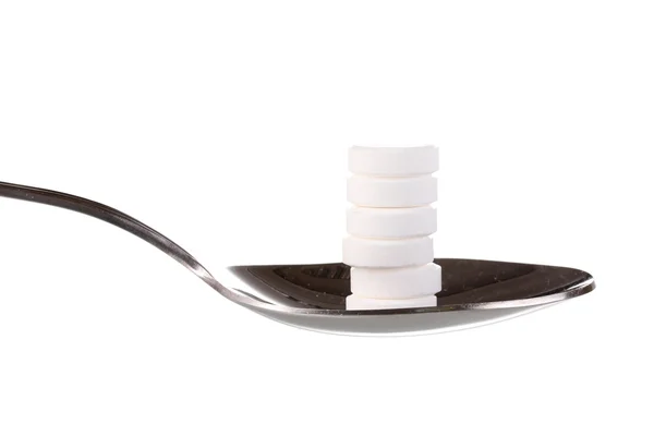 Spoon with pills isolated on white — Stock Photo, Image