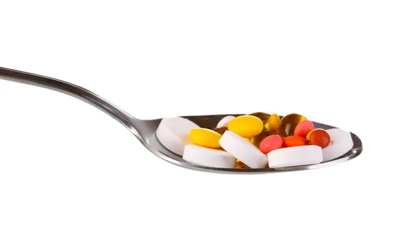 Colher com pílulas isoladas em branco — Fotografia de Stock