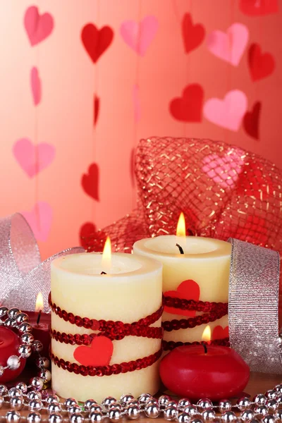 Candles for Valentine's Day on wooden table on red background Stock Picture