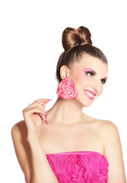 Giovane ragazza come una bambola in abiti rosa con caramelle a forma di cuore isolato su — Foto Stock