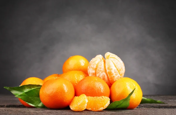 Tangerines με αφήνει στο ξύλινο τραπέζι σε γκρι φόντο — Φωτογραφία Αρχείου